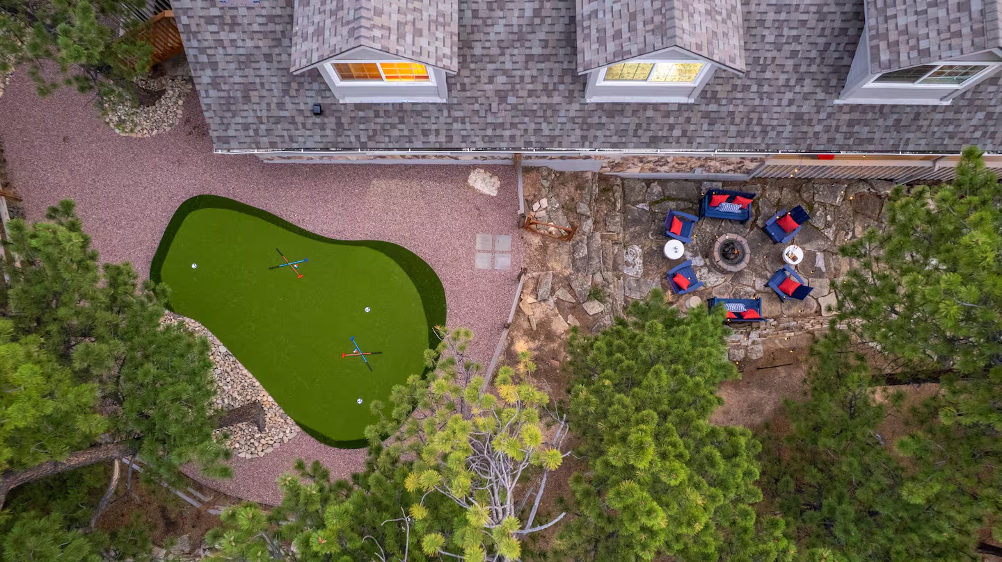 Putting green and fire-pit terrace among tall pines