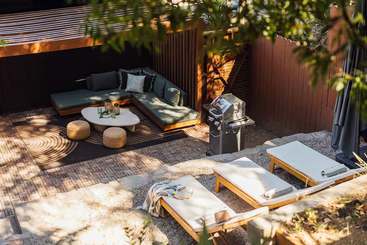A sunlit Hollywood Hills patio with woven furniture and a shaded seating area